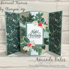 an open christmas card with holly leaves and berries on it, in front of a brick wall