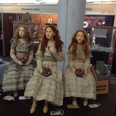 three dolls are sitting in front of a mirror and one is looking at the camera