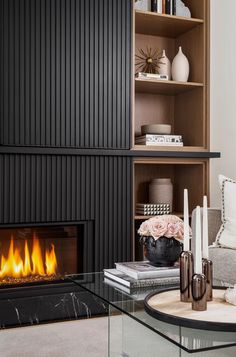 a living room filled with furniture and a fire place in front of a book shelf