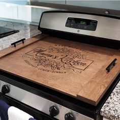 a wooden cutting board sitting on top of an oven