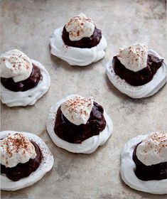 chocolate desserts with whipped cream on top are sitting on a baking sheet and ready to be eaten