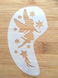 a wooden cutting board topped with a cut out of a woman's head and stars