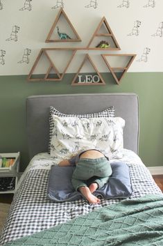 a little boy laying in bed with his head on the pillow and arms behind him