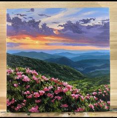 an acrylic painting of pink flowers in the mountains at sunset with clouds above