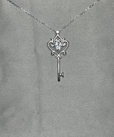 "A stylish necklace for lock and key lovers! Arrives in a wrapped gift box Chain Size: 18\" (45.7 cm) including the clasp Pendant Size: 4 cm X 1.8 cm Main Stone Size: 7 mm X 7 mm (1.5 Carat) Main Stone Shape: Heart Cut Metal: Real Solid 925 Sterling Silver Hallmark: 925 Plating: Rhodium Plated Stones: High Quality Lab Moissanite Diamond Finish: High Polished Nickel Free Lead Free" Elegant Heart-shaped Necklace With Two Keys, Silver Necklace With Two Keys For Gift, Elegant Two Keys Necklace As Gift, Elegant Two Keys Necklace Gift, Elegant Two Keys Necklace For Gift, Key Heart, Sterling Silver Cross Pendant, Silver Cross Pendant, Stylish Necklace