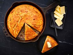 a pie with slices cut out sitting in a pan on a table next to some cheese