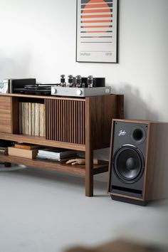 a record player sitting on top of a wooden shelf next to a stereo and speakers