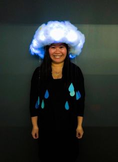 a woman standing in front of a wall with a cloud on top of her head