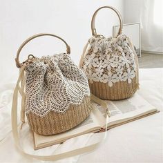 two purses sitting on top of an open book next to each other with lace