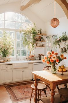 a kitchen filled with lots of furniture and flowers in vases on top of a table