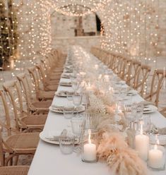 a long table is set with candles and place settings