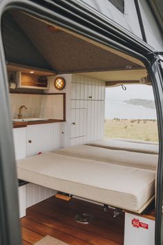 the inside of a camper with a bed and sink