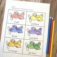 an image of color words that are in the shape of cars on paper with colored pencils next to it