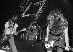 two women playing guitars on stage with one woman standing next to her and the other holding an electric guitar