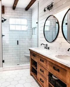 a bathroom with two sinks, mirrors and a walk - in shower next to a toilet