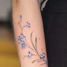 a woman's arm with blue flowers on it