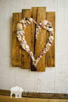 an image of a heart made out of seashells on a piece of wood