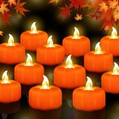 many lit candles are arranged in the shape of pumpkins