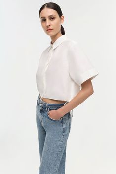 PRE-FALL 2024 WOMEN'S COLLECTION The Ryett Shirt in White. This short sleeve top offers a blend of classic tailoring and contemporary style. The neat collar and clean button-up front give a nod to traditional design, while the cropped cut and breezy short sleeves add a modern twist. The pure white fabric brings an air of freshness and versatility to any outfit, making it an ideal choice for a variety of occasions. Classic Tailoring, Cropped Shirt, Outfit Making, Fall 2024, Crop Shirt, Pre Fall, White Fabric, Pure White, White Fabrics