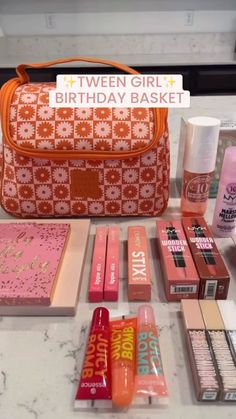 an orange purse sitting on top of a counter next to lipstick and other makeup products