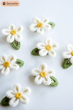 crocheted white and yellow flowers with green leaves