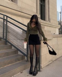 a woman in tights and boots is walking down the stairs with her handbag