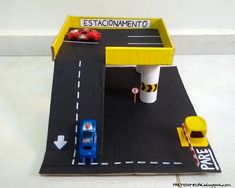 a toy car is parked in front of a gas station with cars on the road