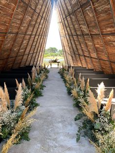 an outdoor ceremony setup with flowers and greenery on the aisle leading up to the altar