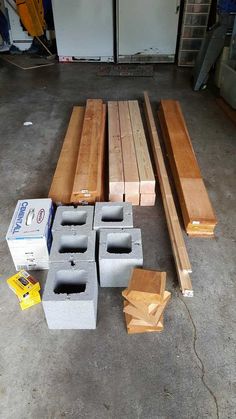 several pieces of wood sitting on the floor next to some boxes and other items in a garage