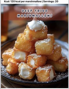 a pile of deep fried marshmallows sitting on top of a black plate