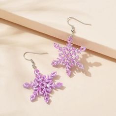 a pair of earrings with purple beads hanging from them