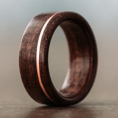 a wooden ring with silver and wood inlays on the inside, sitting on a table