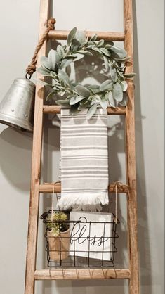 an old ladder is used as a towel rack for towels and other things to hang on