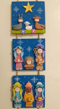 three wooden nativity ornaments hanging on a wall