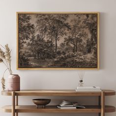 a painting hanging on the wall above a wooden table with vases and other items