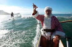 a man dressed as santa claus riding on the back of a boat