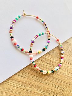 Large and colorful, beaded hoop earrings. Light weight with a bright, summer-y mix of colors. Made with a high quality mix of gorgeous seed beads. ✨Each piece is handmade to order and one-of-a-kind with variations in bead order.✨ Gold plated, 45 mm (1.75 inches) hoops. Looking for smaller sizes? Small Beaded Hoops: https://etsy.me/3bs8SKz Medium Beaded Hoops: https://etsy.me/3xXuyrh 🌎 Packaging 🌎 To be environmentally responsible about packaging we will package orders together in the same box. Colorful Beaded Hoop Earrings For Summer, Adjustable Multicolor Hoop Earrings For Beach, Trendy Multicolor Hoop Earrings For The Beach, Summer Colorful Beaded Round Hoop Earrings, Playful Multicolor Hoop Jewelry, Multicolor Hoop Earrings With Large Beads As Gift, Multicolor Small Hoop Jewelry With Spacer Beads, Multicolor Round Beads Hoop Earrings For Beach, Multicolor Hoop Jewelry With Spacer Beads