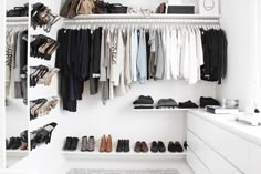 an organized closet with shoes and clothing hanging on the wall next to a counter top