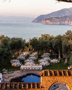 an outdoor dining area overlooking the ocean and mountains