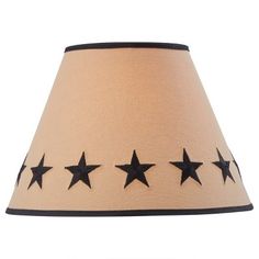 a lampshade with black stars on the bottom and beige fabric shade, hanging from a wall