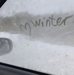 rain drops on the windshield of a car as it sits in front of a window