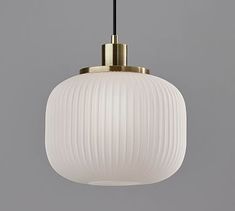 a white and gold light hanging from a ceiling fixture with a black cord attached to it