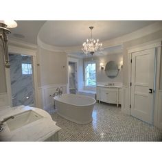 a bathroom with a large tub and chandelier