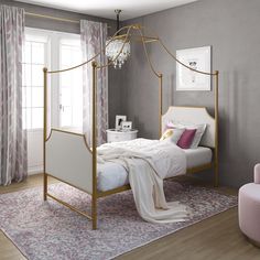 a white bed sitting in a bedroom next to a pink chair and window with curtains