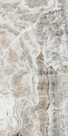 an aerial view of the ocean with waves and sand on it's sides, as seen from above