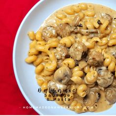 a white plate topped with macaroni and cheese covered in mushroom gravy