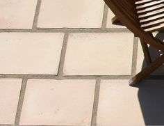 a wooden chair sitting on top of a stone floor