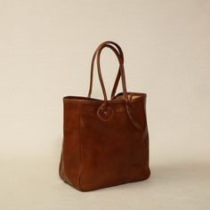 Aero leather tote bag in caramel brown glace leather 14" W x 5.25" D x 14"H Made in the USA Large Luxury Brown Satchel, Classic Satchel With Rolled Handles, Large Elegant Brown Shoulder Bag, Luxury Caramel Leather Shoulder Bag, Classic Cognac Shoulder Bag In Vegetable Tanned Leather, Classic Cognac Vegetable Tanned Leather Shoulder Bag, Luxury Caramel Bag For Everyday Use, Luxury Brown Shoulder Bag In Vegetable Tanned Leather, Timeless Brown Tote Shoulder Bag