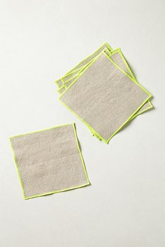 four pieces of cloth sitting next to each other on top of a white tablecloth