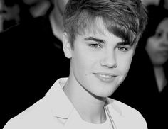 a black and white photo of a young man with short hair wearing a collared shirt